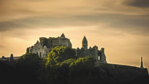 The historic Rock of Cashel castle perched on a hill, showcasing medieval architecture against a dramatic sky.