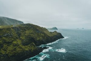 Lush green hillside next to a secluded body of water along the Wild Atlantic Way