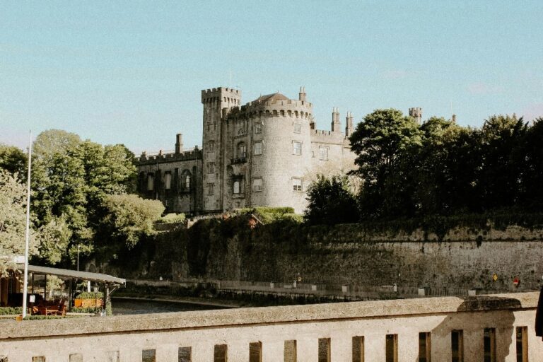 Exterior of Kilkenny Castle with historic clocktower on a sunny day