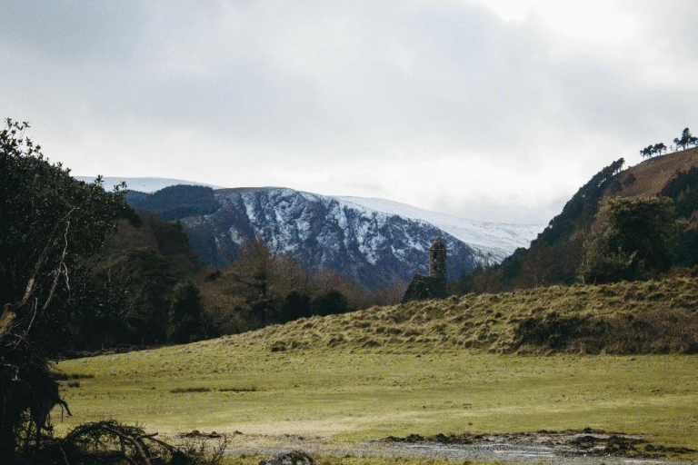 Scenic view of Glendalough Lake surrounded by mountains in the Wicklow region during daylight.