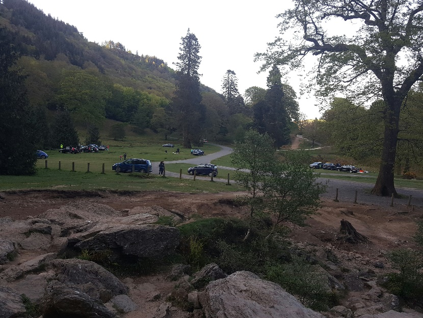 View of green hillside near Waterford with parked cars and scenic coastal horizon