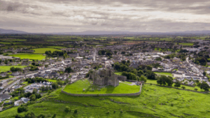 Aerial view of a historic Irish castle on a hill overlooking town and countryside