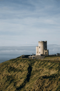 Martello tower on Irish coastline overlooking sea with visitors nearby