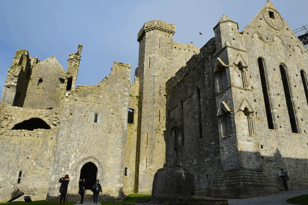 The Rock of Cashel perched on a hill with its medieval ruins and a bright blue sky.