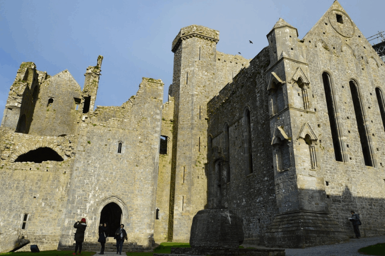 The Rock of Cashel perched on a hill with its medieval ruins and a bright blue sky.