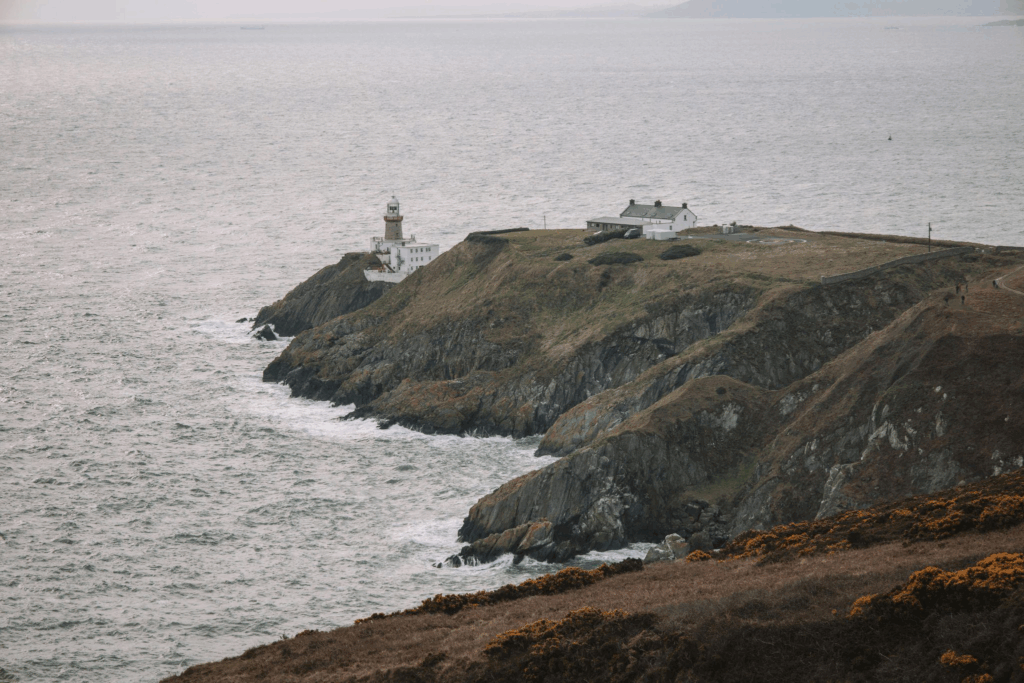 This photo shows a lighthouse by a cliff.