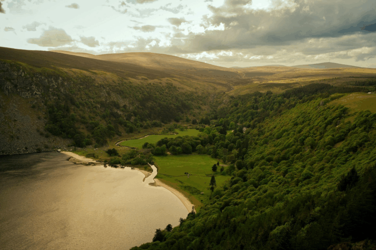 This photo shows a green grassy hill with a body of water in front of it.