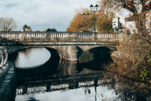 This image shows a bridge over a river with a clock tower.