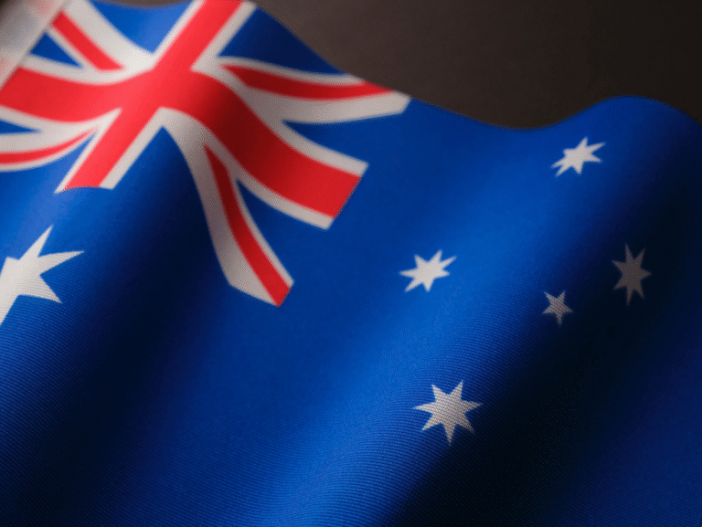 Close-up of the Australian national flag waving against a clear sky.