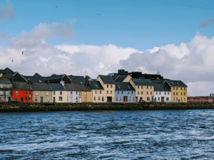 Historic stone buildings along the waterfront and river edge in Galway, Ireland.