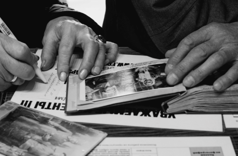 This photo shows a person writing family notes beside old photographs.
