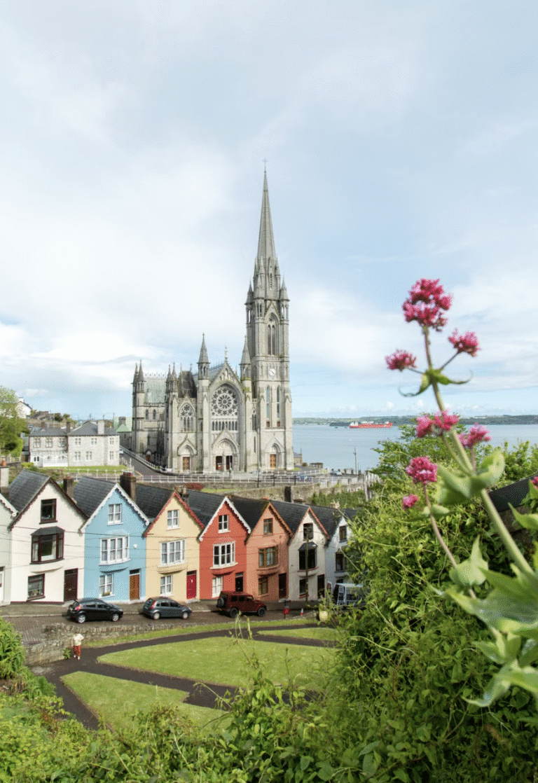 This photo shows a quiet Irish village street with colorful houses and a cathedral.