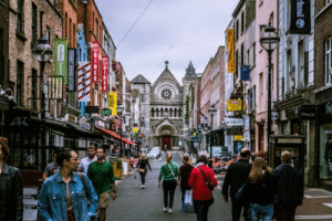 People walking along a traditional Irish street, representing everyday life in historic Ireland.